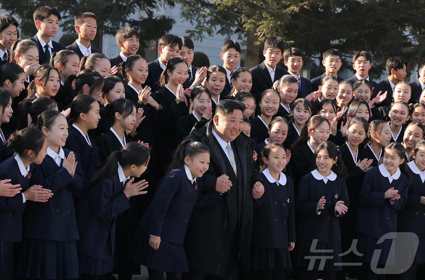 Kim Jong Un, General Secretary of the Workers' Party of Korea, poses for a commemorative photo with the Japanese-Korean Students and Children's Art Troupe, who participated in the 2025 Lunar New Year performance, at the headquarters of the Party's Central Committee / Rodong Sinmun