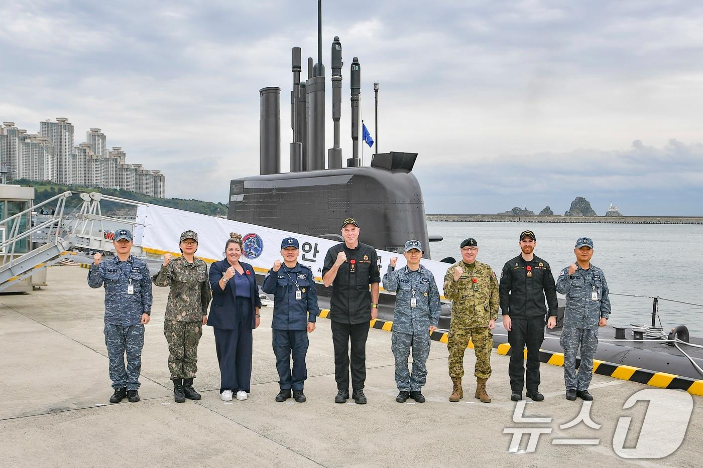 On October 31, Canadian Navy Commander Angus Topshee &#40;center&#41;, accompanied by South Korean Submarine Commander Kang Dong-gu &#40;left&#41; and other naval officials from both nations, poses for a commemorative photo in front of a Dosan Ahn Chang-ho-class submarine during their visit to the Busan Naval Base. &#40;Photo provided by the Republic of Korea Navy&#41; 2025.10.31 / News1