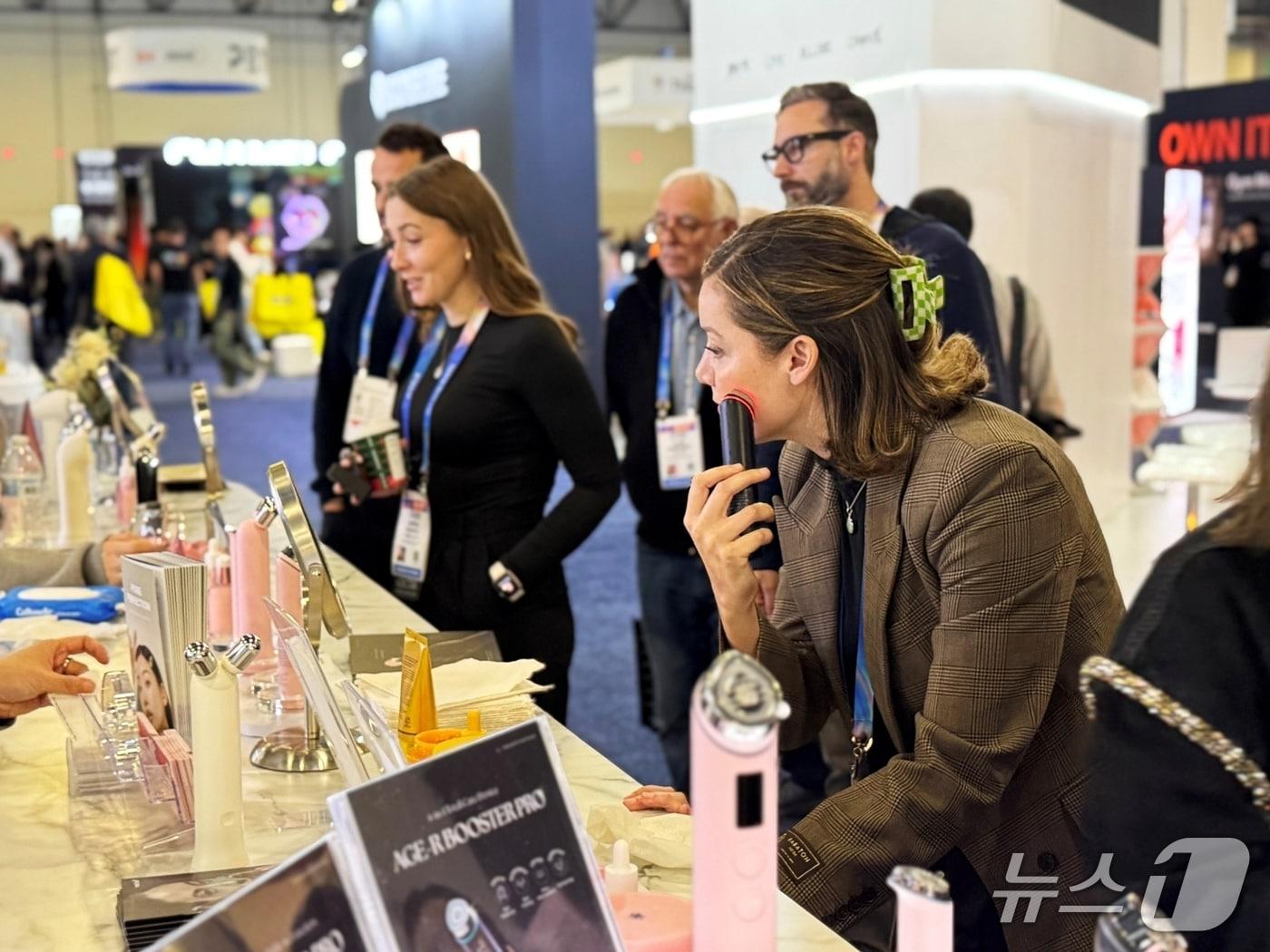A photo of a visitor to APR's CES booth is experiencing the Medicube Age-R beauty device / Provided by APR