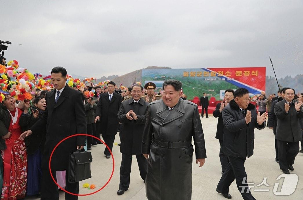 Kim Jong Un, General Secretary of the Workers' Party of Korea, attending the completion ceremony of the Hoeryang County People's Power Plant on November 20, 2025. A bodyguard is seen carrying a bag / Rodong Sinmun