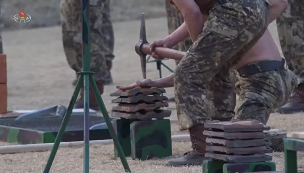 On March 29, Korean Central Television reported on a demonstration performed by combatants in front of Kim Jong Un, General Secretary of the Workers' Party of Korea. The scene of a hand on a roof tile being struck with a sickle / Capture from Korean Central Television (KCTV)