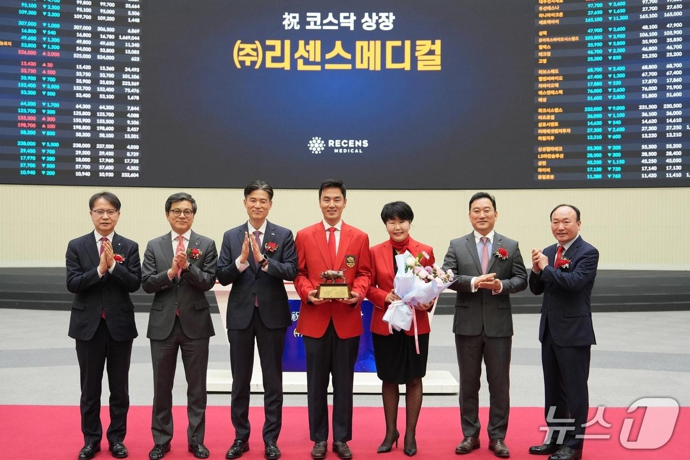 Co-CEOs Kim Geon-ho and Choi Eui-kyung (fourth and fifth from left) of RecensMedical pose for a commemorative photo with officials from the Asia's Exchange’s KOSDAQ Market Division during a listing ceremony. / Courtesy of UNIST